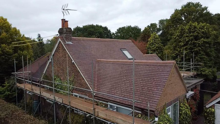 A tiled roof with scaffolding around the property