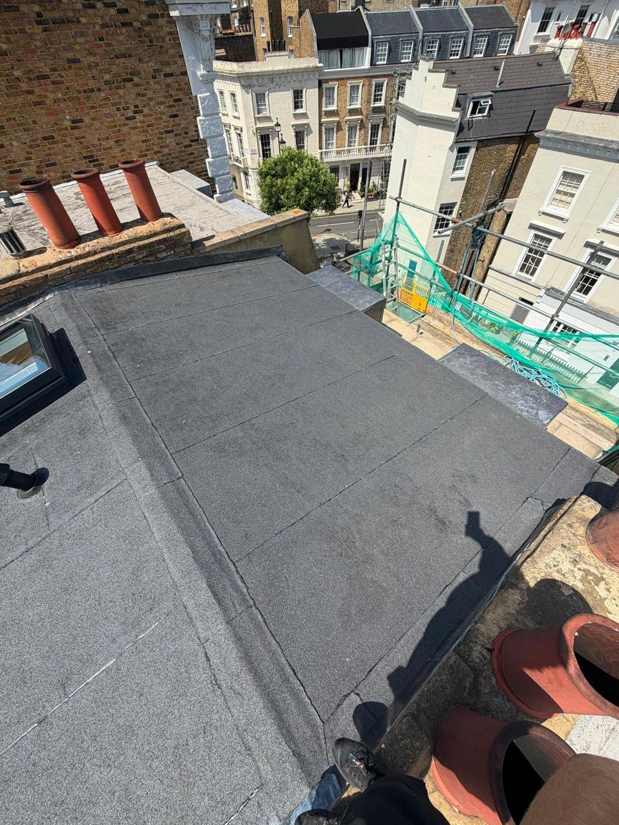 A flat roof running between chimney stacks