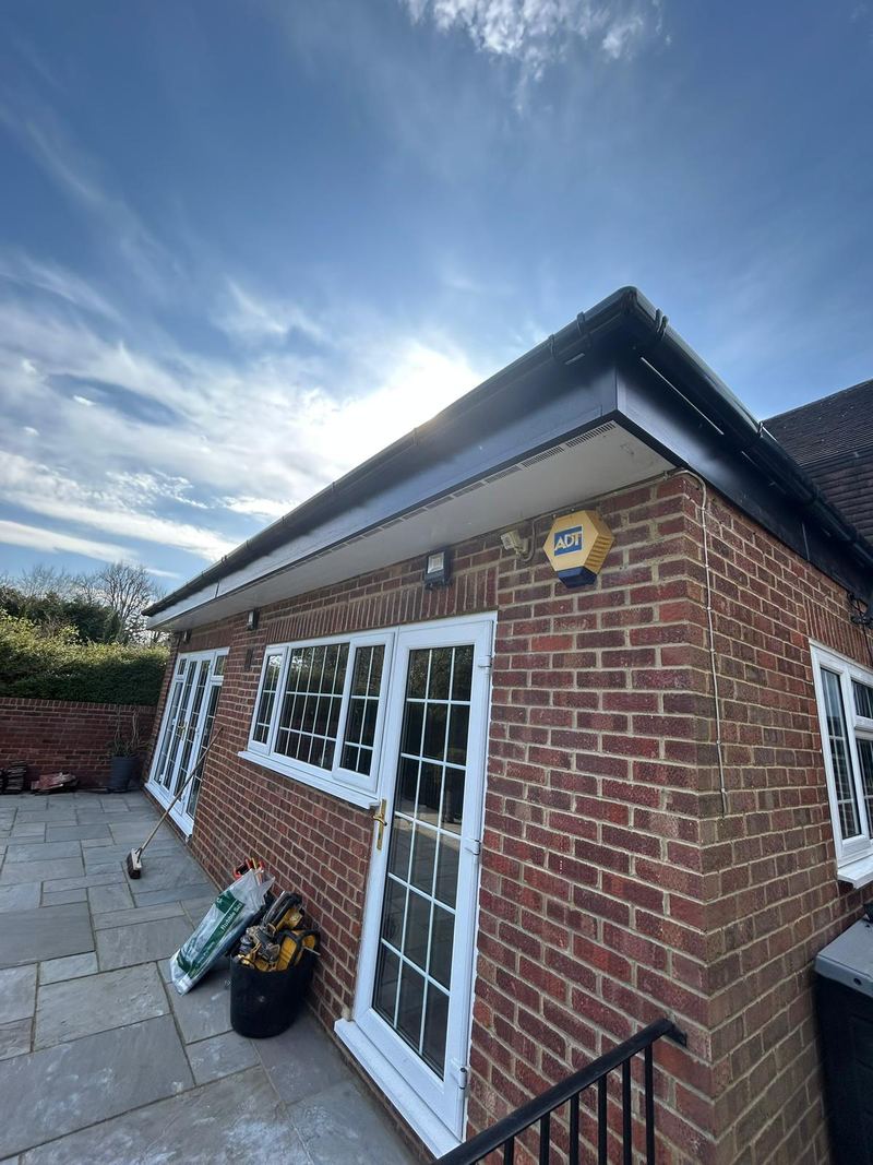 New black uPVC fascia, soffit and guttering along a brick house